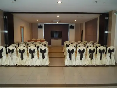 a row of chairs in a room with a screen at Grand Court Hotel in Teluk Intan