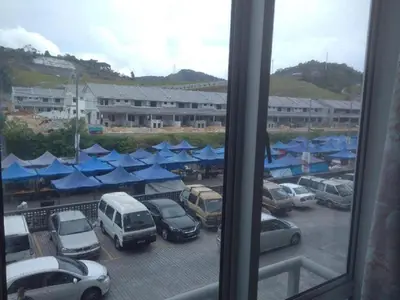 a view of a parking lot with cars and blue umbrellas at Mariana Barrington Square Goldenhills Pasar Malam Cameron Highlands in Cameron Highlands