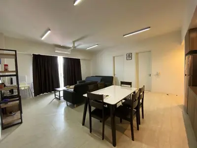 a living room with a table and a couch at By The Sea BeachFront Penang in Batu Ferringhi
