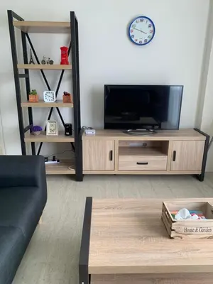 a living room with a television and a coffee table at By The Sea BeachFront Penang in Batu Ferringhi