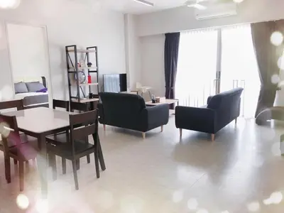 a living room with a table and chairs at By The Sea BeachFront Penang in Batu Ferringhi