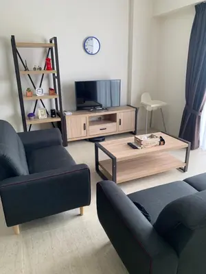 a living room with two couches and a coffee table at By The Sea BeachFront Penang in Batu Ferringhi