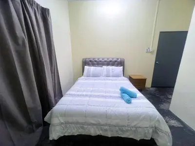 a bedroom with a bed with a blue object on it at Leisure Homestay in Kampong Peruntun