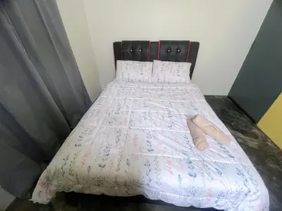 a bed with a pair of slippers on it at Leisure Homestay in Kampong Peruntun