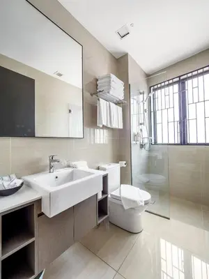 a bathroom with a sink and a toilet and a mirror at Hutton Central Hotel Managed by The Ascott Limited in George Town