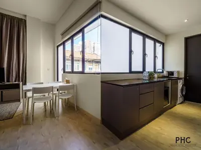 a kitchen with a table and chairs and a large window at Hutton Central Hotel Managed by The Ascott Limited in George Town
