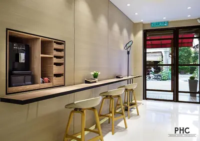 a bar in a restaurant with stools in a room at Hutton Central Hotel Managed by The Ascott Limited in George Town