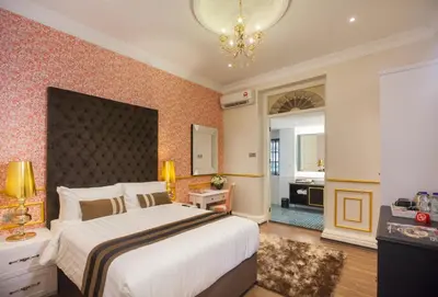 a bedroom with a large bed and a bathroom at Apple Heritage Hotel in George Town