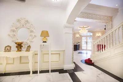 a hallway with a staircase and a mirror on the wall at Apple Heritage Hotel in George Town