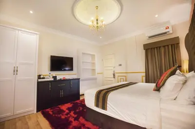 a bedroom with a bed and a chandelier at Apple Heritage Hotel in George Town