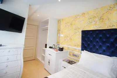 a bedroom with a bed with a blue headboard at Apple Heritage Hotel in George Town