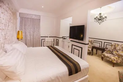 a bedroom with a bed and a flat screen tv at Apple Heritage Hotel in George Town