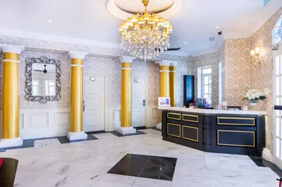 a large room with yellow columns and a chandelier at Apple Heritage Hotel in George Town