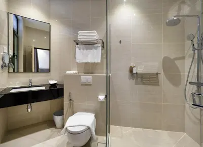 a bathroom with a shower and a toilet and a sink at Magazine Vista Hotel Managed by The Ascott Limited in George Town