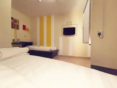 a bedroom with a bed and a tv on the wall at Abby by the river in Ipoh
