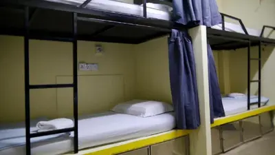 two bunk beds in a room with blue curtains at Abby by the river in Ipoh