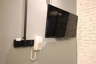a tv and a phone hanging on a wall at 68 Boutique Hotel in Sitiawan