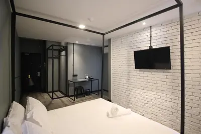 a bedroom with a brick wall and a bed with a tv at 68 Boutique Hotel in Sitiawan