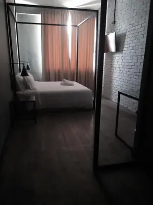 a bedroom with a white bed and a mirror at 68 Boutique Hotel in Sitiawan