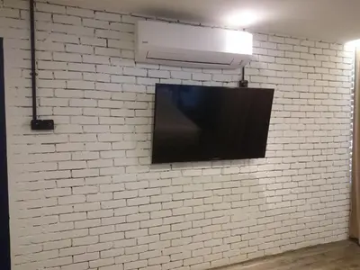 a flat screen tv mounted on a white brick wall at 68 Boutique Hotel in Sitiawan
