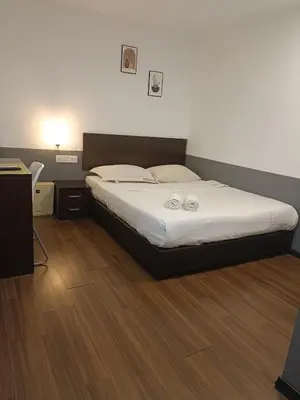 a bedroom with a bed with two towels on it at SO Hotel in George Town