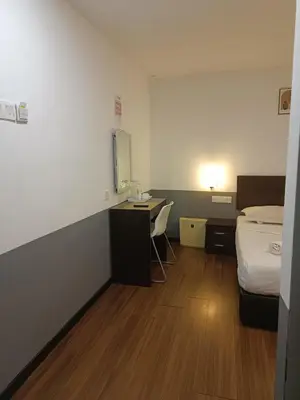 a room with a bed and a desk and a bed and a bed at SO Hotel in George Town