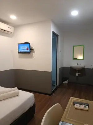 a hotel room with a bed and a tv on the wall at SO Hotel in George Town