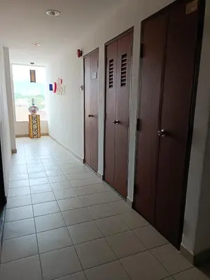 a hallway with brown doors and a tile floor at SO Hotel in George Town
