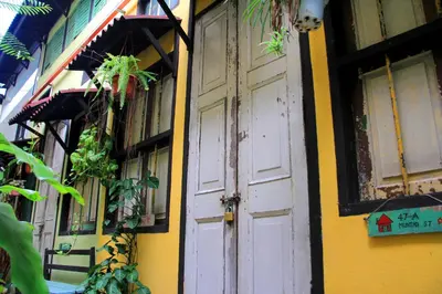 a yellow and white building with a white door at MoonTree47 in George Town