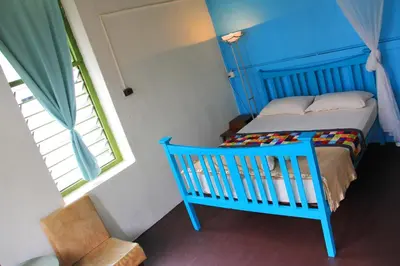 a bedroom with a blue crib and a window at MoonTree47 in George Town
