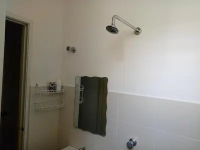 a bathroom with a green towel and a shower at Miker Homestay in Seri Iskandar