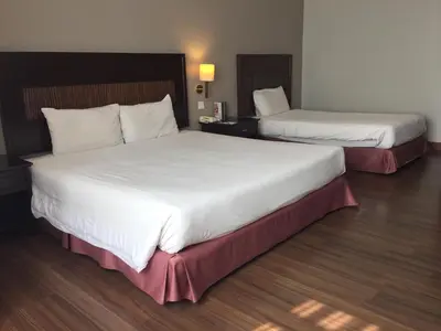 two beds in a hotel room with white sheets at Grand Kampar Hotel in Kampar