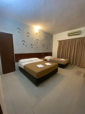 a hotel room with two beds and a wall with faces at Pangkor Bay View Beach Resort in Pangkor