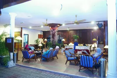 a restaurant with blue chairs and tables and tablesearcher at Pangkor Bay View Beach Resort in Pangkor