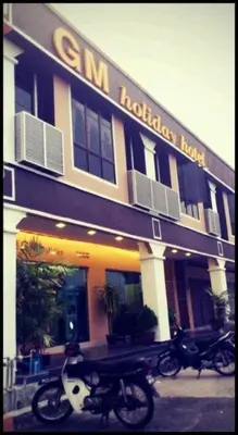 two motorcycles parked in front of a building at GM Holiday Hotel in Lumut