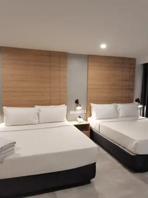 two beds in a hotel room with two beds sidx sidx sidx at Coral Bay Resort in Pangkor