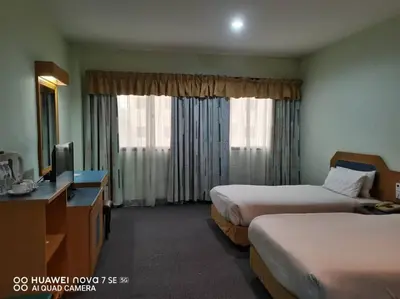 a hotel room with two beds and a television at Coral Bay Resort in Pangkor