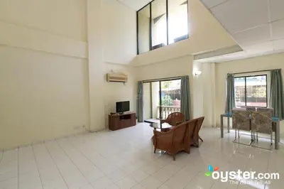 a living room with a tv and a table and chairs at Coral Bay Resort in Pangkor