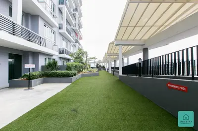 a corridor of an apartment building with green grass at JOMSTAY Octagon Ipoh Suites in Ipoh