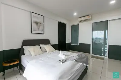 a bedroom with a large white bed and a window at JOMSTAY Octagon Ipoh Suites in Ipoh