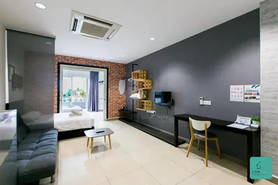 a bedroom with a bed and a desk in a room at JOMSTAY Octagon Ipoh Suites in Ipoh