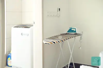 a table with a phone on top of it next to a refrigerator at JOMSTAY Octagon Ipoh Suites in Ipoh