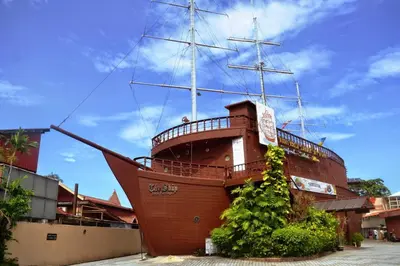 a large wooden ship parked next to a building at 5-BEDROOM FERRINGHI HOUSE with WIFI , NETFLIX , BBQ SET , 5 MINUTES WALK to BEACH in Batu Ferringhi