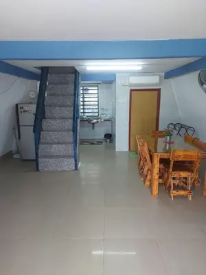 a dining room with a table and a staircase at Panorama Homestay in Jeram