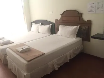 two twin beds in a hotel room with at Hotel Sri Malim Sungkai in Sungkai