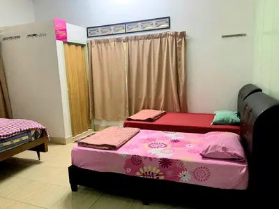 two beds in a room with pink and purple sheets at Sakura Guest House in Cameron Highlands