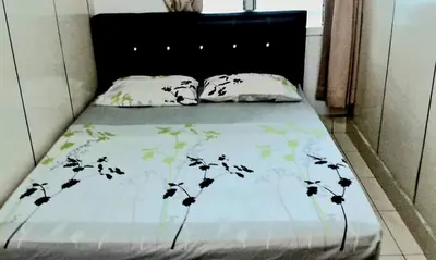 a bed with a black headboard and two pillows at Sakura Guest House in Cameron Highlands