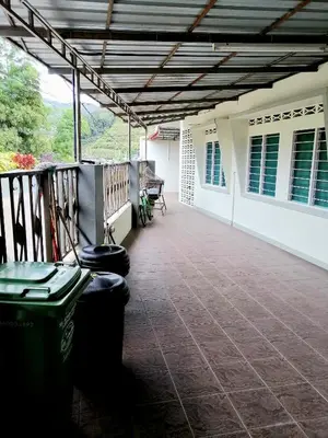 a porch with two trash cans on a house at Sakura Guest House in Cameron Highlands