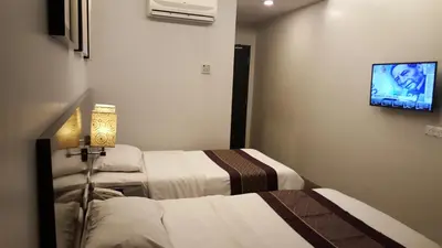 a hotel room with two beds and a flat screen tv at Super 8 Hotel @ Georgetown in George Town