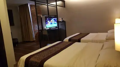 a hotel room with two beds and a television at Super 8 Hotel @ Georgetown in George Town